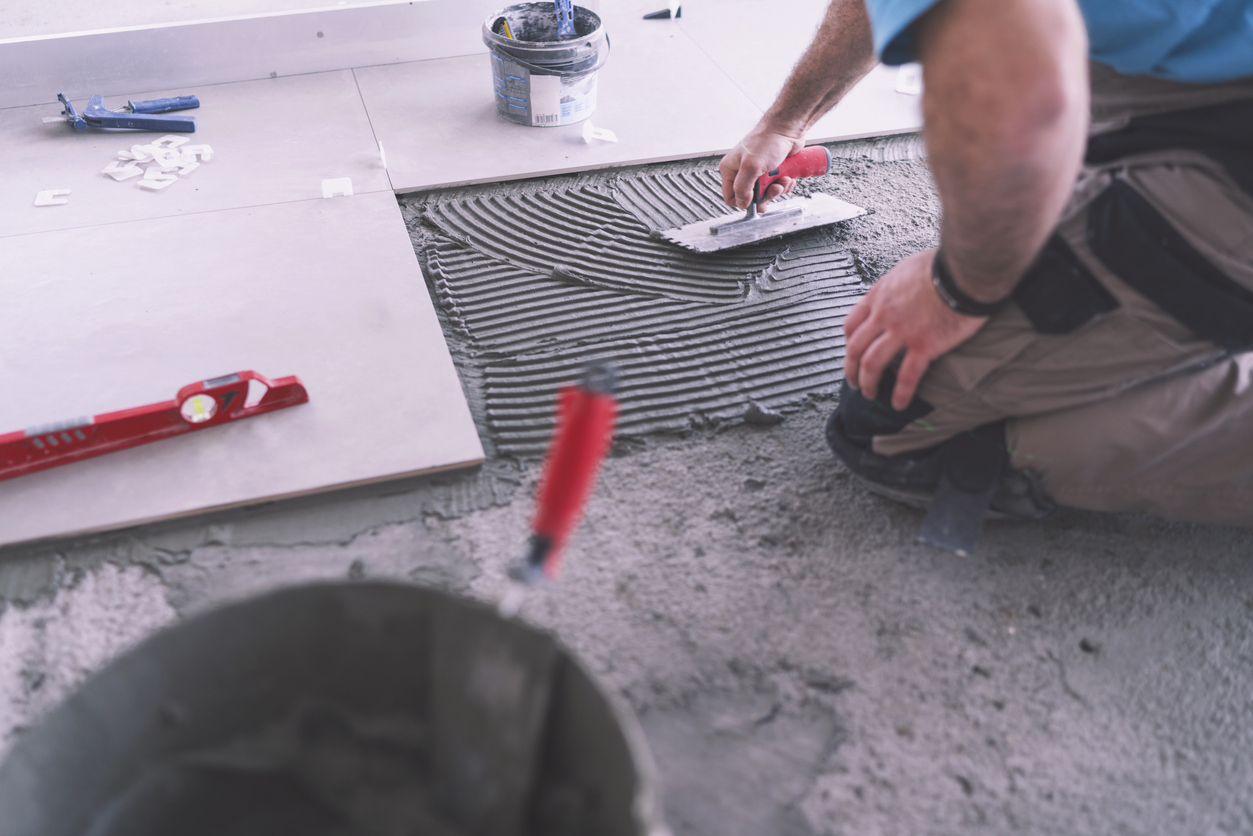 Tiler applying adhesive, attended the TANZ Conference